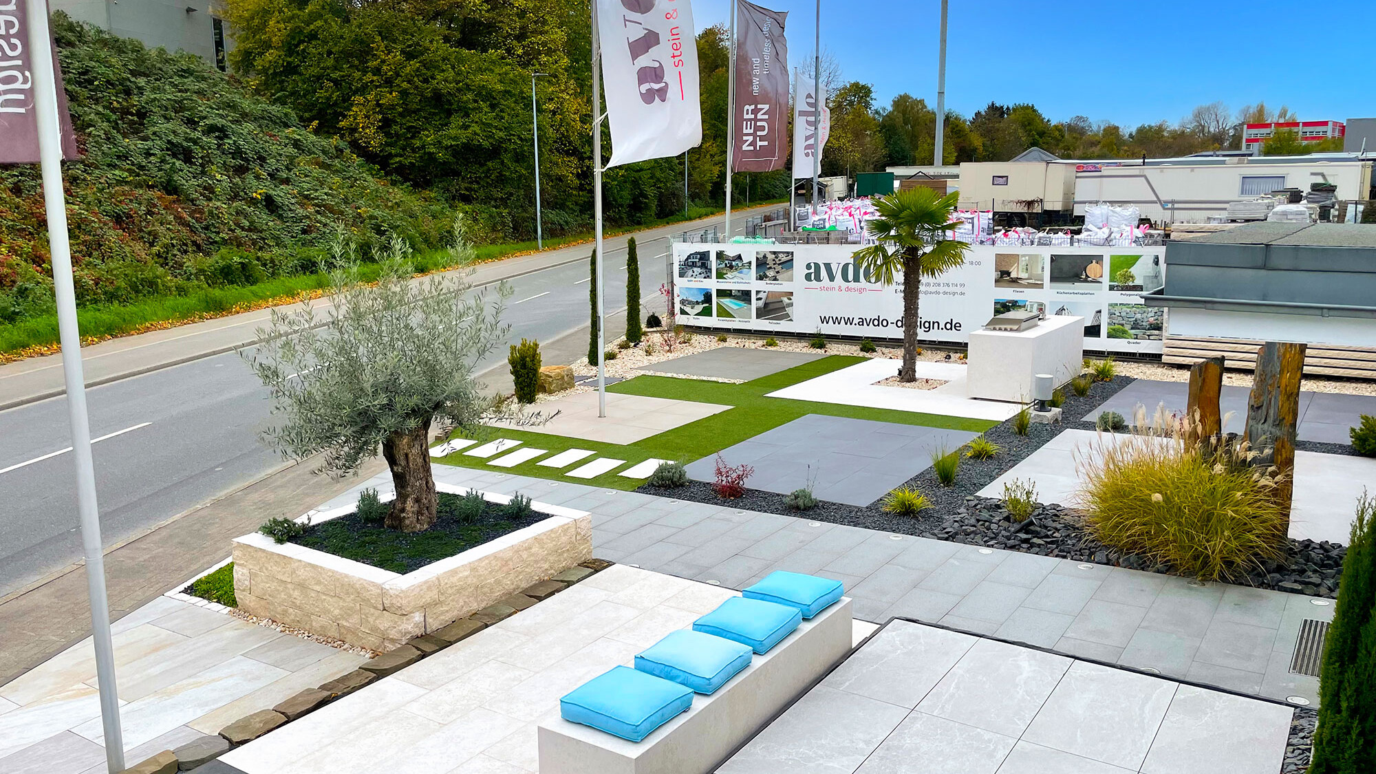 Outdoor-Ausstellung bei avdo design mit verschiedenen Steinarten, Outdoor-Küche, Bepflanzung und Gestaltungsideen