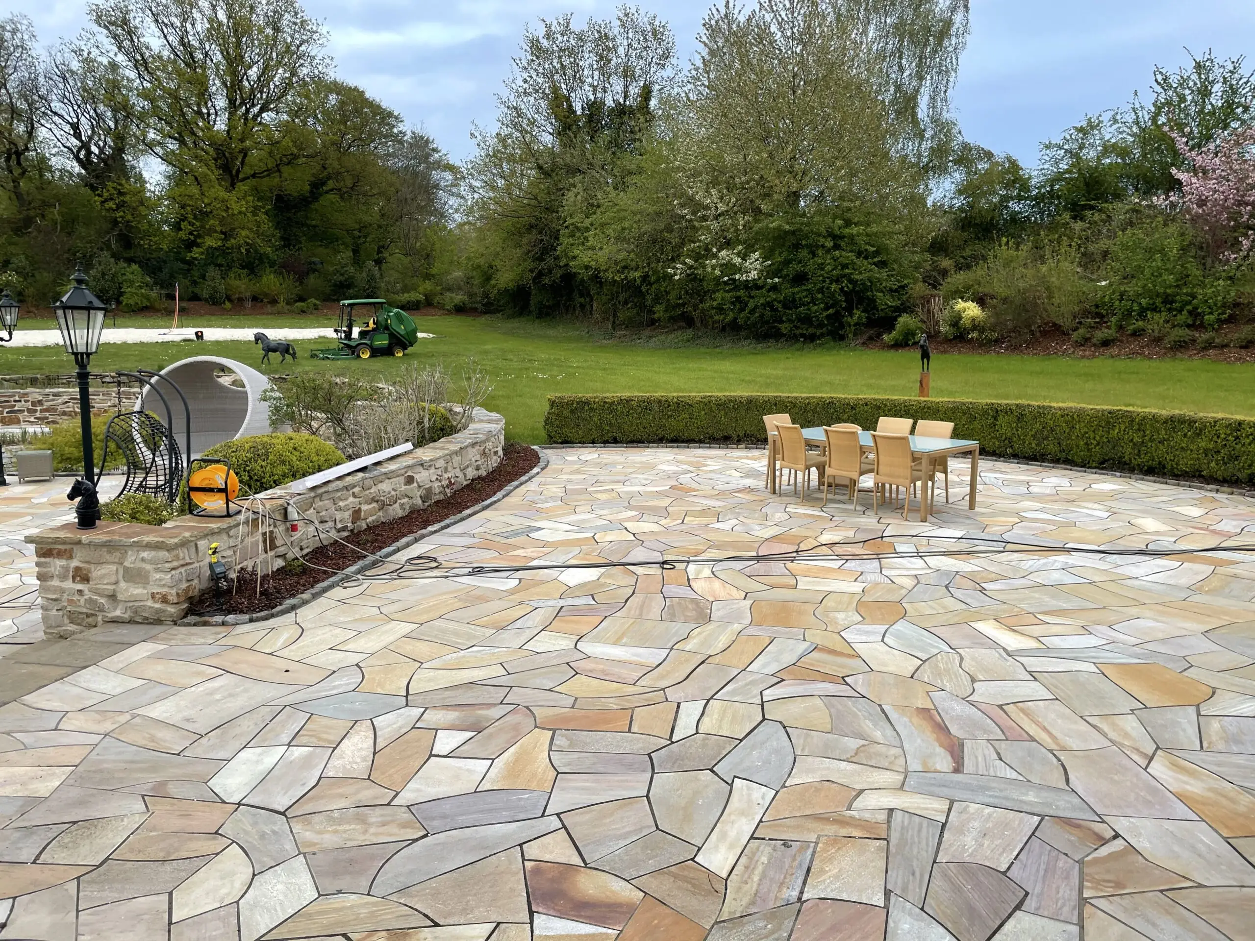 Große Terrasse mit Polygonalplatten aus Naturstein und moderner Gartengestaltung.