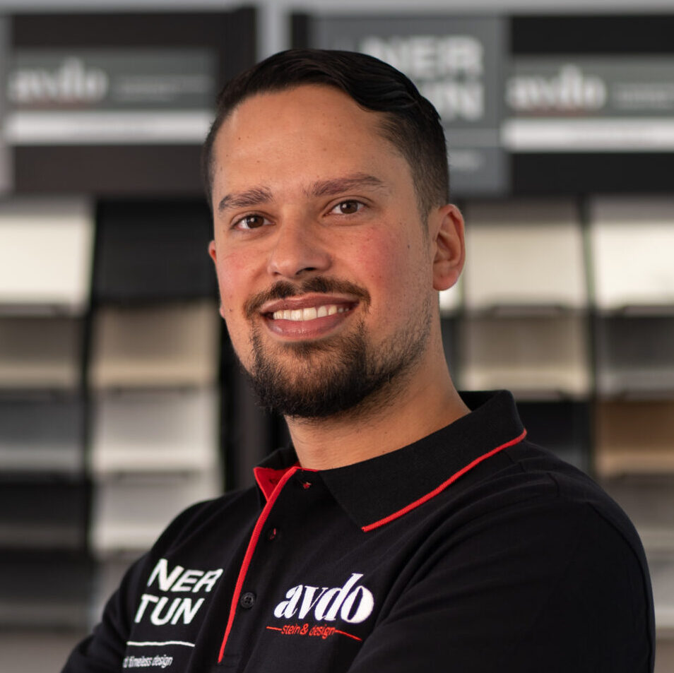 Simon Avdo, Geschäftsführer von avdo design, vor einer Auswahl an Steinmustern