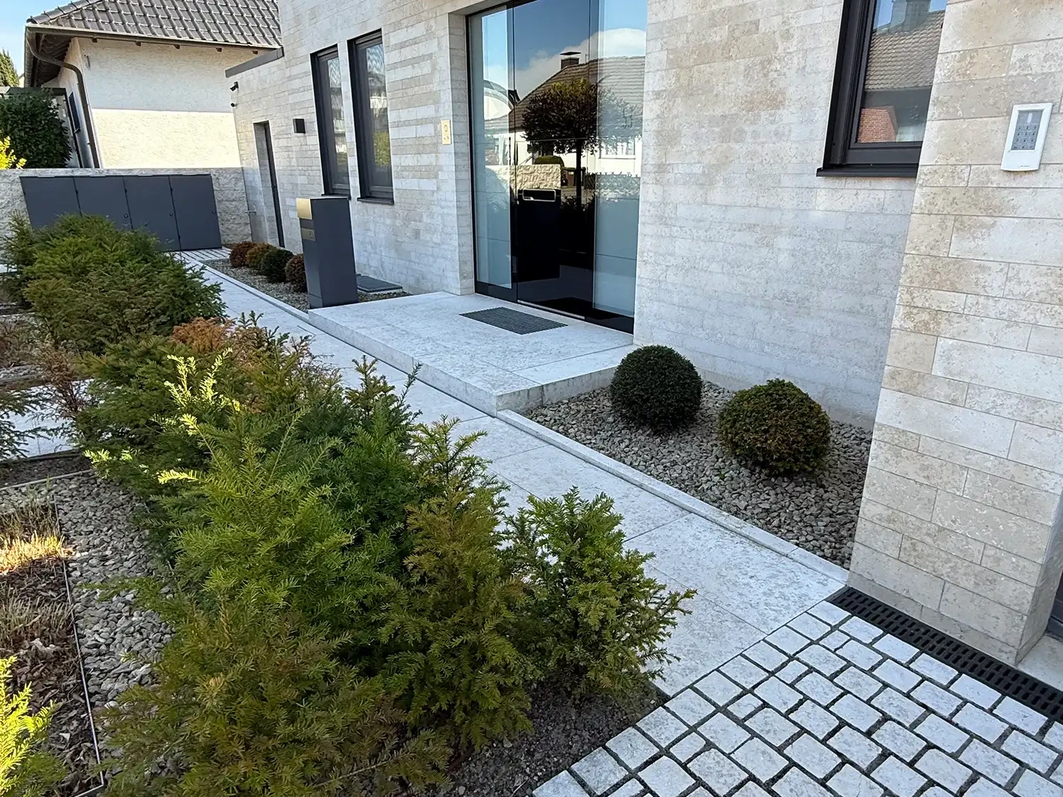 Pflastersteine Naturstein Reihenpflaster am modernen Hauseingang