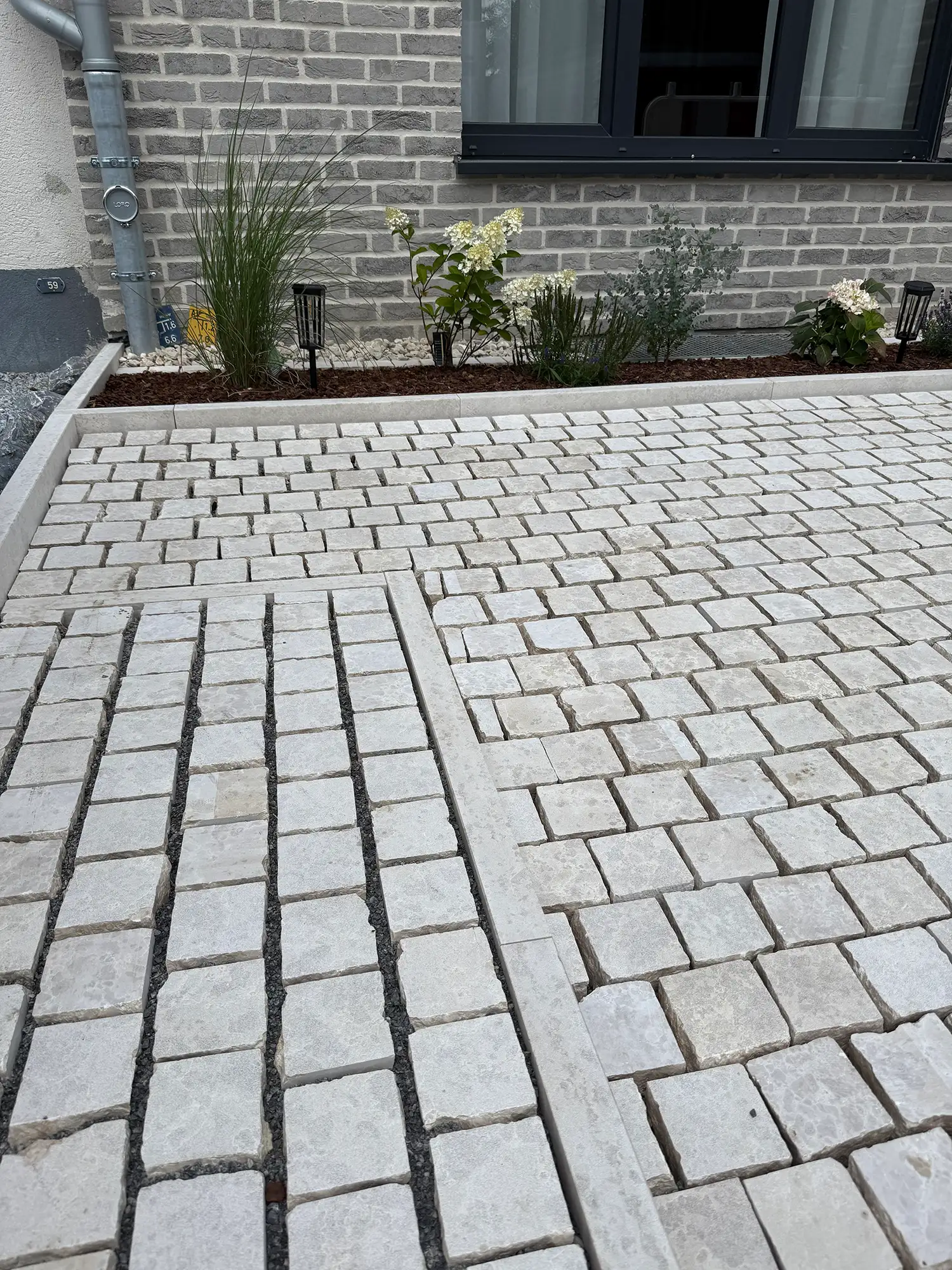 Pflastersteine Naturstein aus hellem Kalkstein vor Wohnhaus
