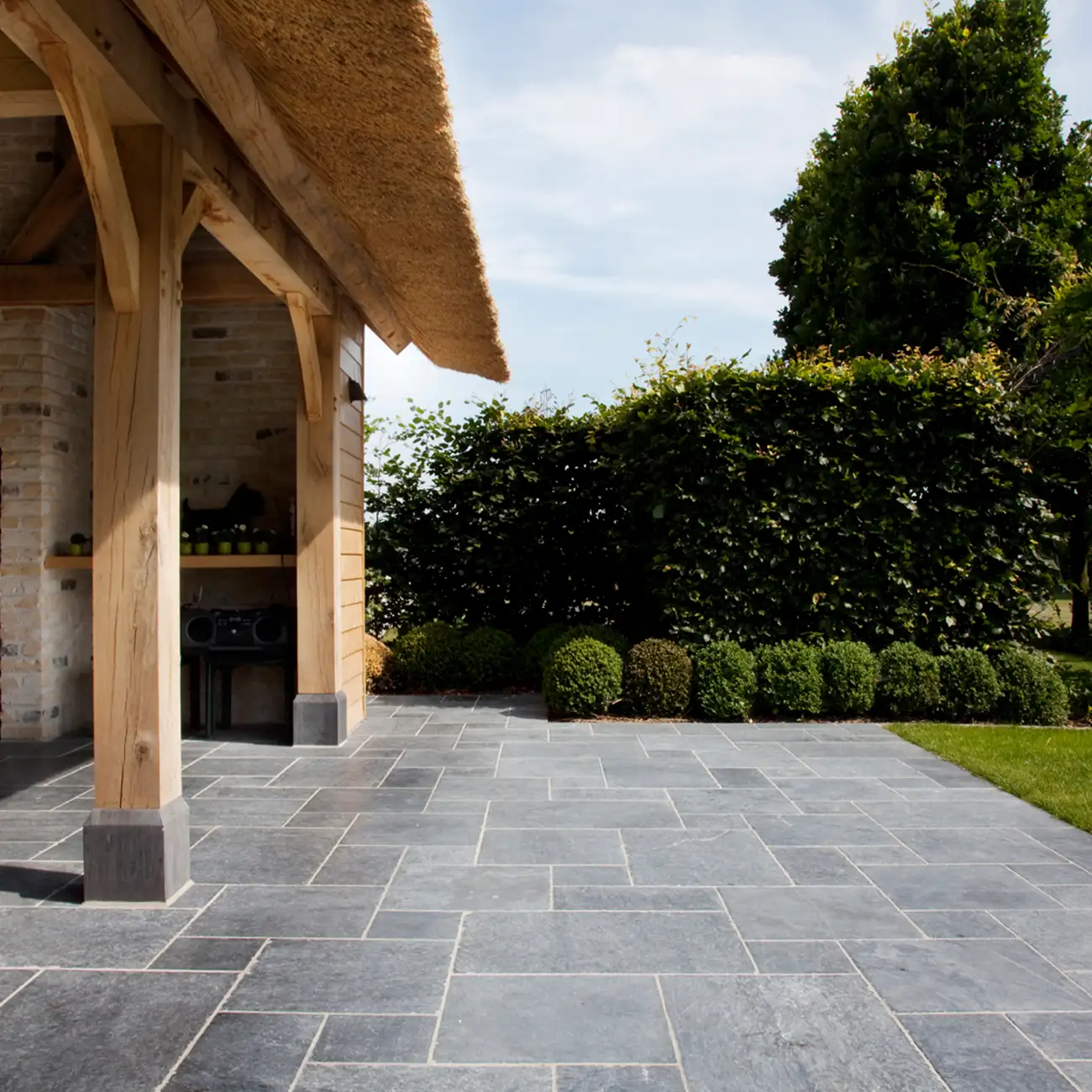 Terrasse mit Bodenplatten aus Naturstein im Garten