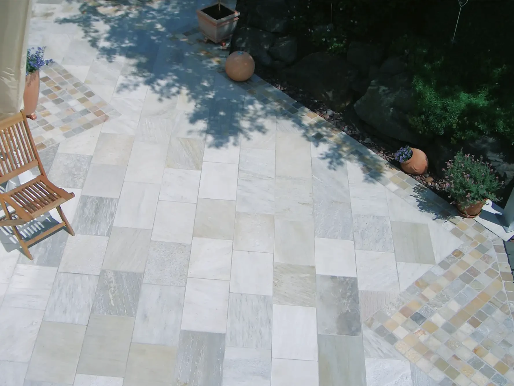 Terrasse mit großformatigen Bodenplatten aus Naturstein im modernen Garten