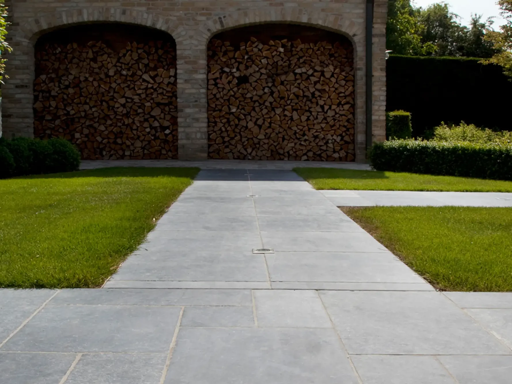 Gartenweg mit Bodenplatten aus Naturstein im modernen Garten
