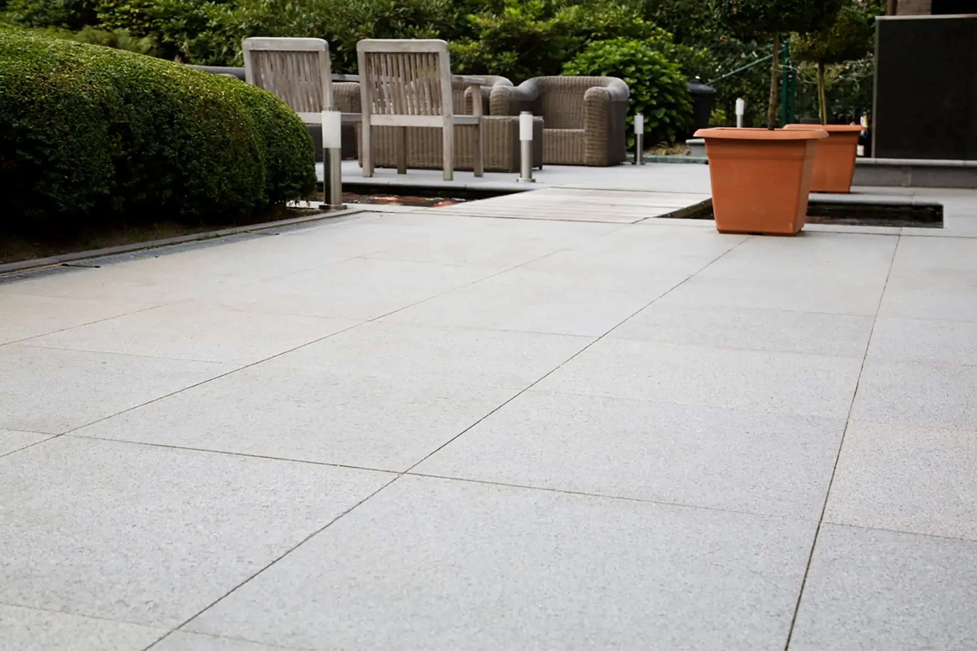 Terrasse mit Bodenplatten aus Granit Cristallo Naturstein im modernen Gartenbereich