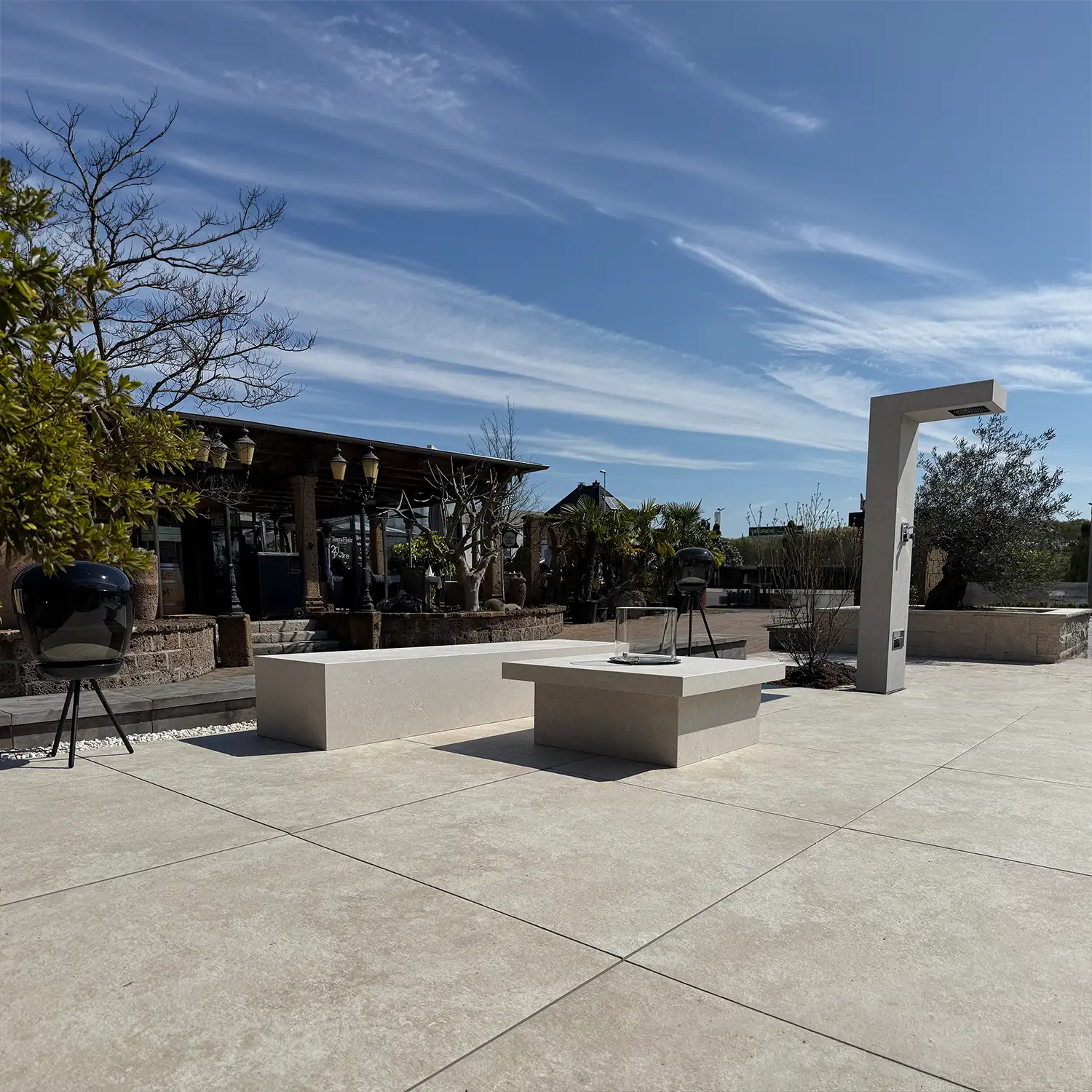 Gro&szlig;formatige Naturstein-/ Keramik-Terrassenplatten mit Sitzquadern und Outdoordusche in der Gartenausstellung avdo design M&uuml;lheim an der Ruhr