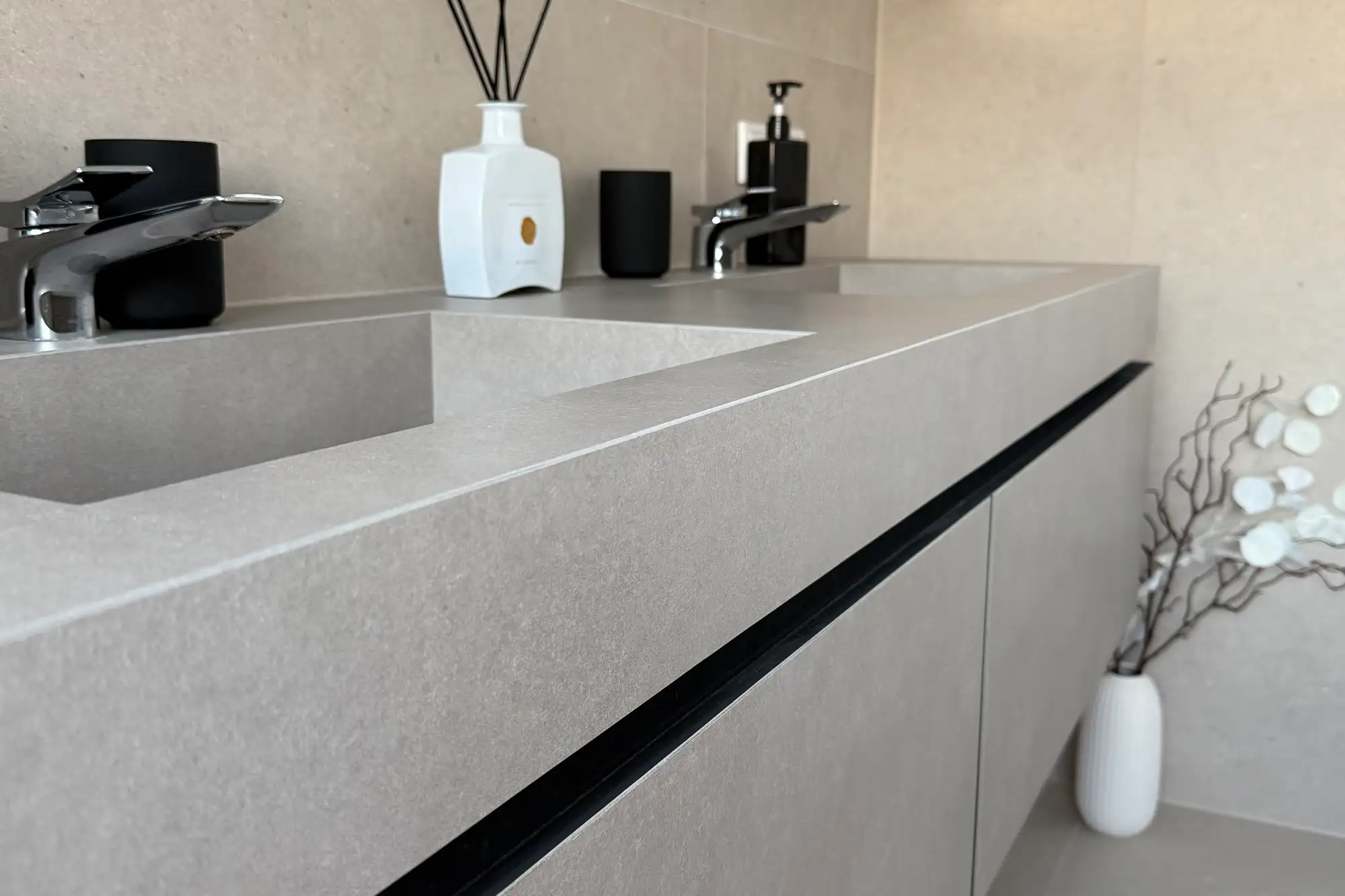 Detailansicht eines modernen Waschtischs in heller Steinoptik mit integriertem Becken, Armatur und hochwertiger Badgestaltung
