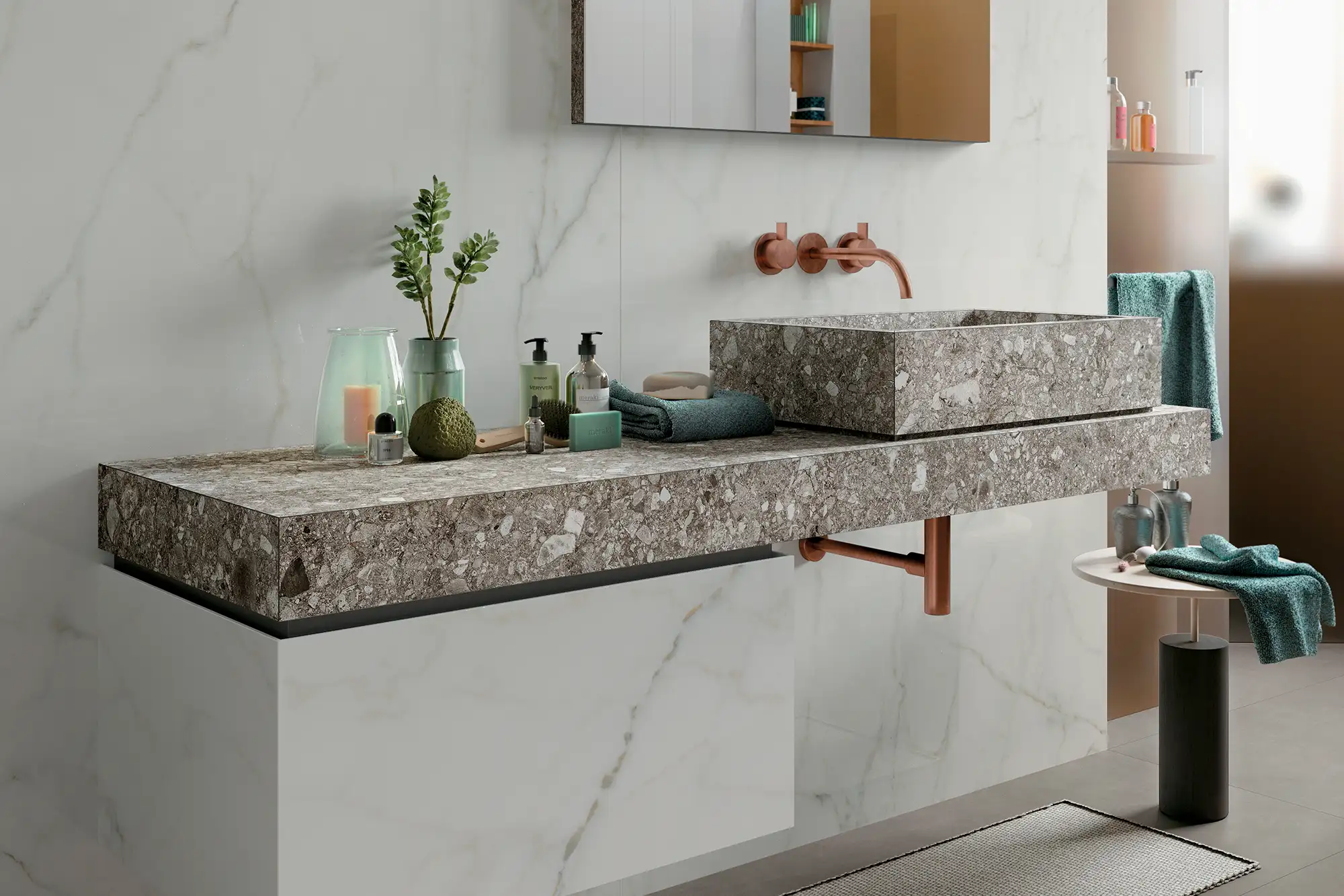Moderner Waschtisch in Terrazzo-Optik mit integriertem Becken, Kupferarmatur und heller Wandverkleidung