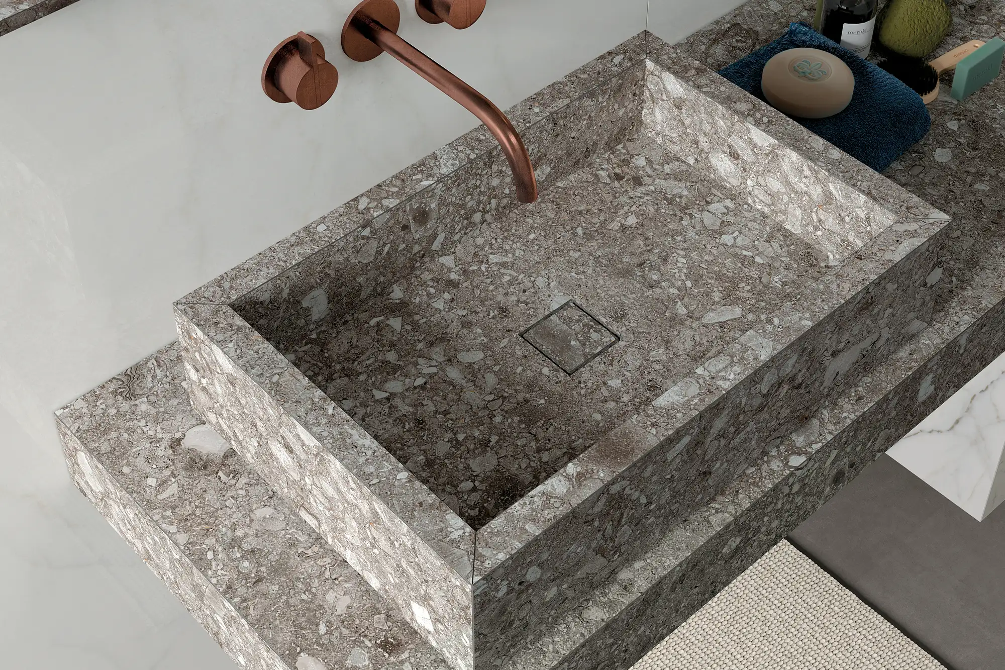 Moderner Waschtisch in Terrazzo-Optik mit integriertem Becken, Kupferarmatur und eleganter Steinoberfläche