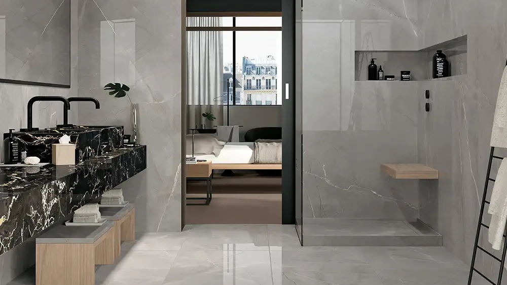 Graues Designbad mit Keramikplatten in glänzender Marmoroptik, Walk-in-Dusche und Marmor-Waschtisch.