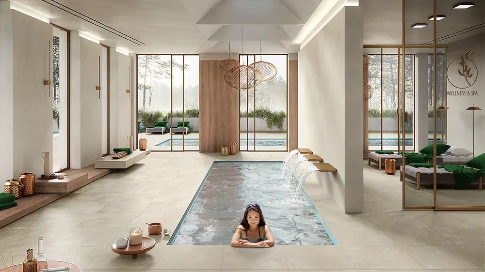 Wellnessbereich mit Indoor-Pool und sandbeigen, matten Keramikplatten in durchgefärbtem Feinsteinzeug.