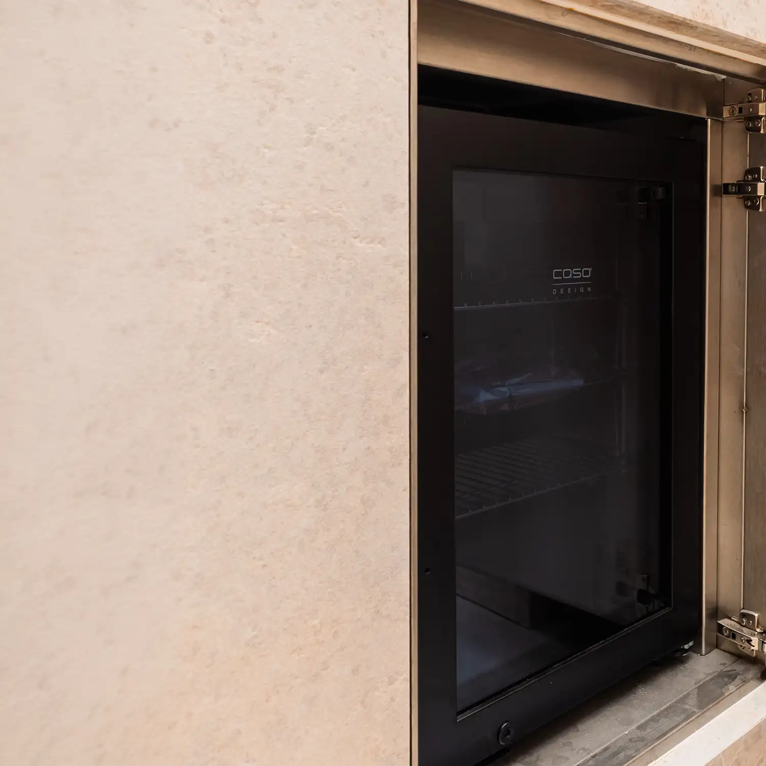 Integrierter Kühlschrank von CASO Design in einer Outdoorküche aus Naturstein